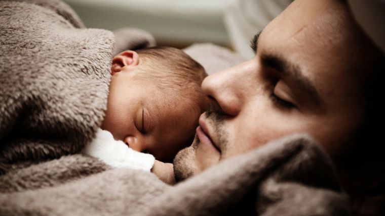 A man cuddling a baby